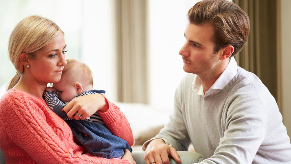 Young couple with baby looking sad