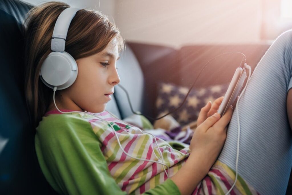 Niña adolescente con la tablet y los cascos.